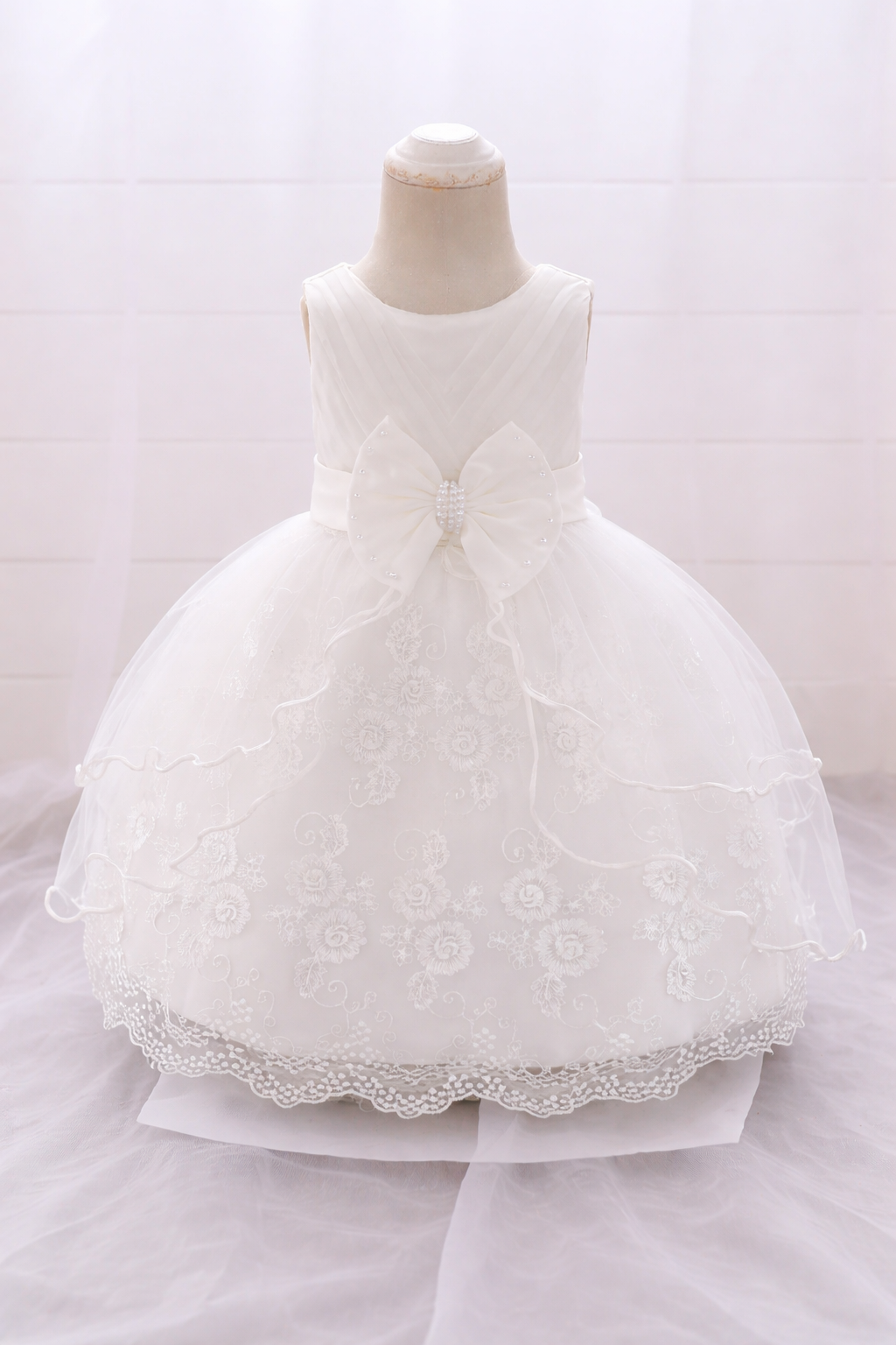 White floral embroidered baby frock with scalloped lace hem and pearl bow
