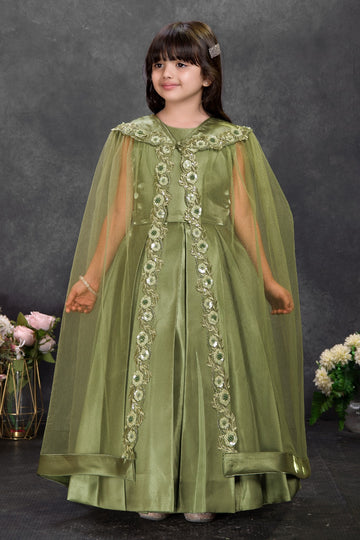 Young girl wearing elegant olive green satin party dress with floral sequin embellishments and sheer cape