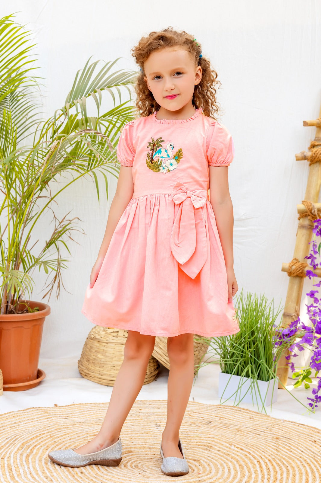 Peach puff-sleeve cotton frock for girls with flamingo embroidery and bow